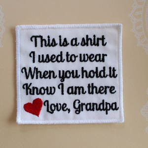May include: White fabric patch with black embroidered text that reads "This is a shirt I used to wear When you hold it Know I am there Love, Grandpa". A red heart is embroidered below the text.