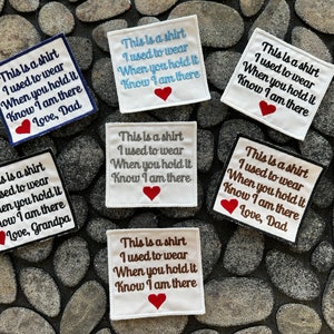 May include: Six white fabric patches with embroidered text that reads "This is a shirt I used to wear When you hold it Know I am there" with a red heart and the words "Love, Dad" or "Love, Grandpa".