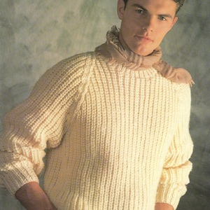 May include: A cream-colored knitted sweater with a ribbed texture. The sweater has a crew neck and long sleeves.