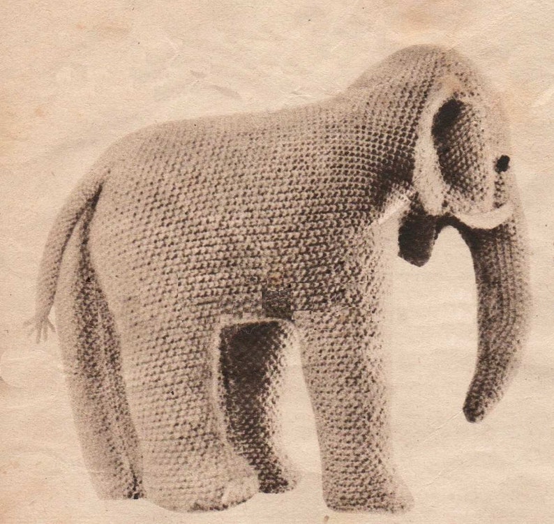 Puede incluir: Un juguete de elefante de peluche tejido a crochet en color marr&oacute;n claro. El elefante tiene una trompa larga y orejas grandes.