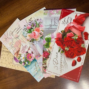 May include: A stack of greeting cards with floral and red rose designs. The cards have the text "Best Wishes", "Happy Birthday", "With Warmest Thoughts", and "With Warmest Thoughts" in English and Russian.