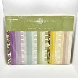 May include: A pack of Anna Griffin Decorative Impressions paper in the Old Paris Palette. The package contains 12 sheets of printed paper and 18 sheets of printed cardstock, each measuring 12 inches by 12 inches, featuring floral and striped patterns.