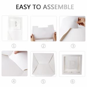 May include: A six-step assembly guide for a white cardboard box with a clear window. The box is designed to hold a gift or other item. The steps are numbered 1 through 6 and show how to fold and assemble the box.