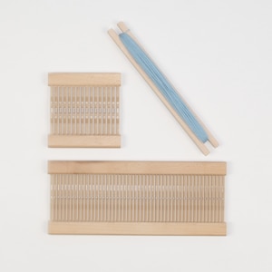 May include: Two wooden weaving looms with a light blue skein of yarn. The smaller loom is 10 inches wide and the larger loom is 18 inches wide.