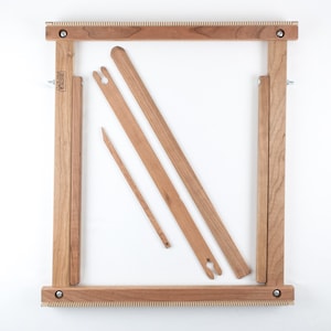 Op de afbeelding: Een houten weefgetouw met een frame, twee hevels, een shuttle en een stok shuttle. Het weefgetouw is gemaakt van natuurlijk hout en is klaar om te worden gebruikt voor weven.