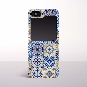 May include: A phone case with a mosaic tile design in shades of blue, white, and gold. The case has a rectangular cutout for the phone's camera and screen. The pattern includes floral and geometric motifs.