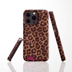 May include: A smartphone case featuring a brown and black leopard print pattern. The case displays a triple camera cutout on the back and a small rectangular opening at the bottom edge. Two additional side views of the case are shown separately.