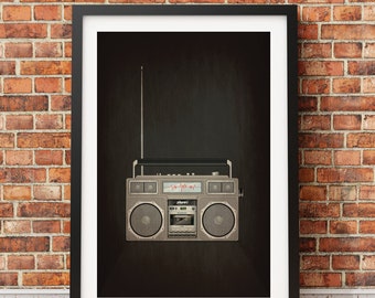 Puede incluir: Una radiocasete de estilo vintage con acabado plateado y negro. La radiocasete tiene un reproductor de casetes, un sintonizador de radio y un altavoz a cada lado. La radiocasete está enmarcada en un marco negro y se muestra contra una pared de ladrillo.