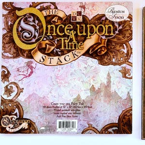 May include: The Once Upon a Time Stack, a paper crafting kit, features a decorative cover with the title in gold and brown. The stack includes 101 sheets of 12" x 12" (30.5 cm x 30.5 cm) paper with fairy tale-inspired designs, including a paisley pattern.