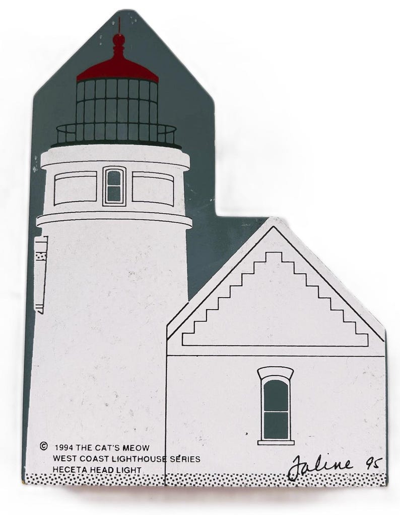 Puede incluir: Objeto decorativo de madera con forma de faro. El faro es blanco con la parte superior roja y un fondo gris oscuro. El texto dice "1994 The Cat's Meow West Coast Lighthouse Series Heceta Head Light".