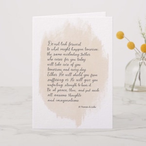 Op de afbeelding: Gevouwen wenskaart met een lichtbeige aquarel achtergrond. De kaart bevat een handgeschreven citaat van St. Franciscus van Sales in donkergrijze letters. Het citaat moedigt vrede en geloof aan.