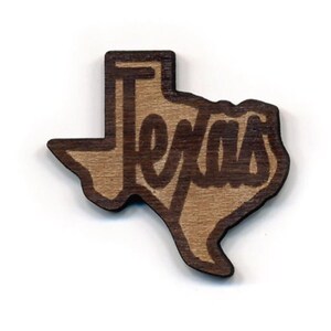 May include: A wooden cutout of the state of Texas with the word "Texas" written in a stylized font inside the outline.