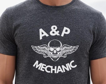 May include: A dark heather grey t-shirt with a white graphic of a skull with wings and the text "A&P Mechanic".