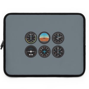 May include: A grey laptop sleeve featuring six black and white aircraft instrument gauges. The gauges include an airspeed indicator, an altimeter, a heading indicator, a turn coordinator, a vertical speed indicator, and a compass.