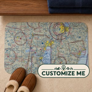 May include: A rectangular bath mat featuring a detailed aeronautical sectional chart with various navigation symbols, airspace boundaries, and topographical markings. A white rectangular overlay in the bottom right corner displays the text CUSTOMIZE ME.