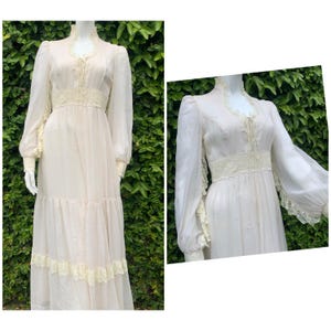 Puede incluir: Un vestido largo, blanco y fluido con detalles de encaje. El vestido tiene un corpi&ntilde;o ajustado y una falda completa con m&uacute;ltiples capas. Las mangas son largas y tienen ribetes de encaje en los pu&ntilde;os.