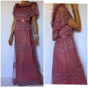 Puede incluir: Un vestido largo de color rosa polvoriento con una superposici&oacute;n de encaje y una faja de sat&eacute;n. El vestido tiene un escote con volantes y mangas cortas.