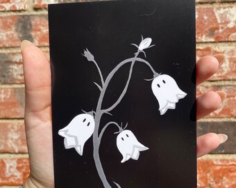May include: A black and white illustration of a flower with three white bell-shaped flowers on a black background.