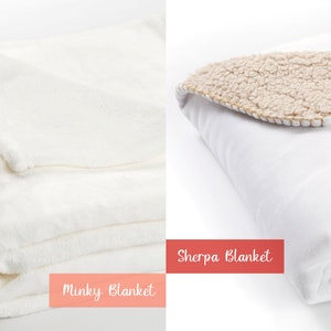 May include: Two white blankets, one with a fluffy texture labeled "Minky Blanket" and the other with a brown sherpa lining labeled "Sherpa Blanket".