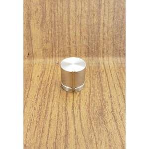 May include: A cylindrical silver-colored metal control knob featuring a smooth flat top surface and a vertical grooved texture along the side. A single thin vertical line is indented into the side of the knob to serve as a position indicator.