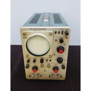 May include: Vintage Type 503 Oscilloscope with a light blue top and a cream-colored body. The front panel features a circular screen with a grid, numerous knobs, and labeled controls. The text "TYPE 503 OSCILLOSCOPE" is visible.