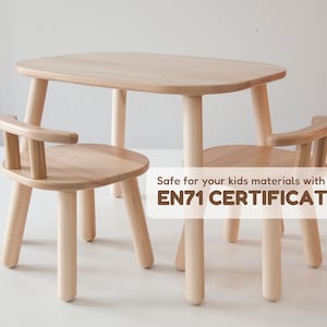 K&ouml;nnte beinhalten: Ein helles Kinder-Tisch- und Stuhl-Set aus Holz. Der Tisch hat eine abgerundete rechteckige Oberseite und vier Beine. Der Stuhl hat einen runden Sitz, eine geschwungene R&uuml;ckenlehne und vier Beine. Der Text auf dem Bild lautet: Safe for your kids materials with an EN71 CERTIFICATE.
