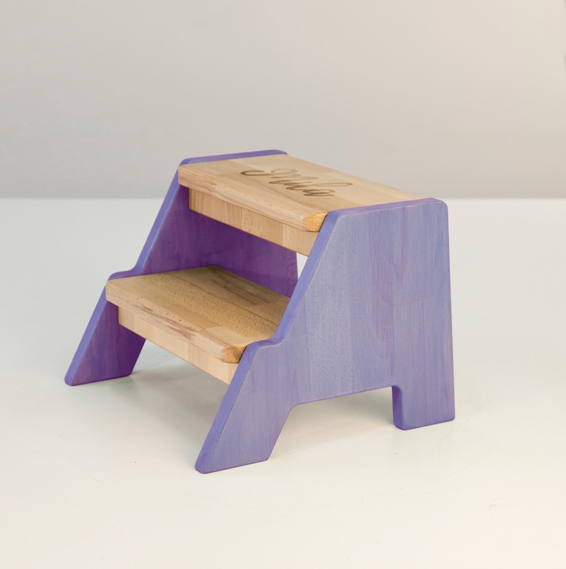 A purple and light-colored wooden step stool with a wooden top and two steps.