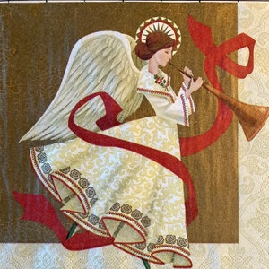 May include: A white angel with gold wings and a red ribbon plays a golden trumpet. The angel is wearing a white dress with gold and red trim. The background is a brown and gold patterned paper.