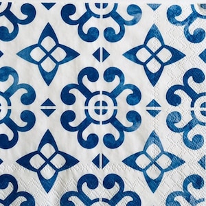 Puede incluir: Servilletas de papel blancas con un patrón geométrico azul y blanco. El patrón presenta un diseño repetitivo de flores estilizadas y cuadrados.