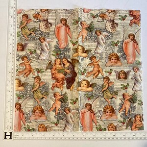 Puede incluir: Una tela blanca con un patr&oacute;n repetitivo de &aacute;ngeles tocando instrumentos musicales y cantando. Los &aacute;ngeles est&aacute;n representados en una variedad de poses y visten t&uacute;nicas blancas y doradas. La tela est&aacute; decorada con hojas de acebo y bayas.