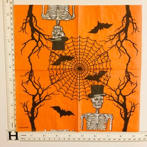 May include: Orange Halloween themed paper napkins with a black spiderweb design, black bats, and skeletons wearing top hats.