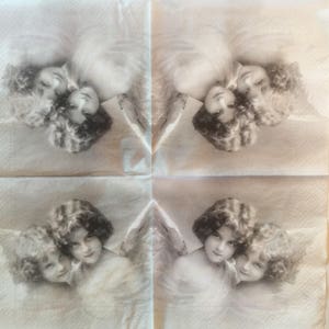 May include: Four square napkins with a sepia-toned angel design. Each napkin features a pair of cherubic figures with curly hair and feathered wings. The angels are depicted in a vintage, antique style.