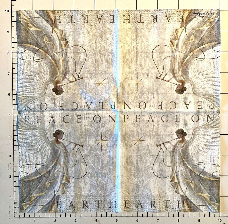 K&ouml;nnte beinhalten: Eine wei&szlig;e Papierserviette mit einem Vintage-Design, das zwei Engel zeigt, die Musikinstrumente spielen. Der Text "Peace on Earth" wird viermal auf der Serviette wiederholt.