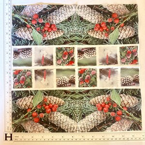 Op de afbeelding: Een witte stof met een herhalend patroon van dennenappels, hulstbesjes en groenblijvende takken. De stof heeft een vintage uitstraling met een verweerde rand rond elk beeld.