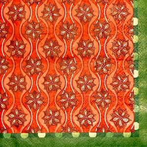 May include: Orange fabric with a repeating pattern of brown stylized flowers. The fabric has a green border with white polka dots.