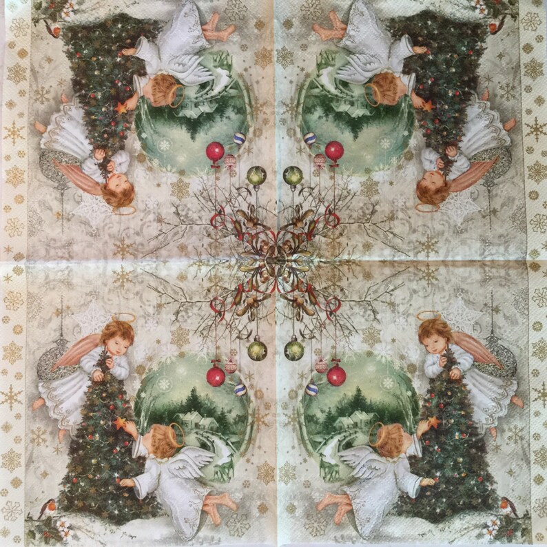 Puede incluir: Una servilleta de Navidad de estilo vintage con cuatro &aacute;ngeles decorando un &aacute;rbol de Navidad con adornos. El fondo es de color crema con un patr&oacute;n de copo de nieve y detalles dorados.