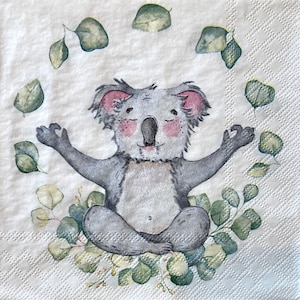 Puede incluir: Un koala gris sentado en una postura de yoga con los brazos extendidos y las piernas cruzadas. El koala está rodeado de hojas verdes de eucalipto.