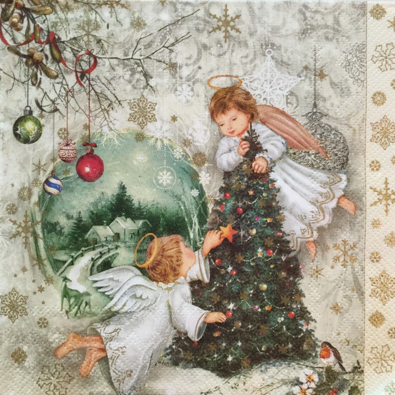 Puede incluir: Dos &aacute;ngeles decoran un &aacute;rbol de Navidad con adornos y una estrella. El &aacute;rbol es verde y los &aacute;ngeles llevan t&uacute;nicas blancas con halos. El fondo es una escena de invierno nevada con un peque&ntilde;o pueblo en la distancia.