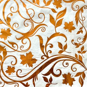 May include: White background with a gold metallic pattern of leaves and swirls. The pattern is reminiscent of fall foliage.