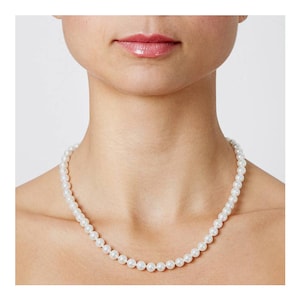 Może przedstawiać: Klasyczny naszyjnik z pereł o prostym wzorze. Naszyjnik wykonany jest z białych pereł i nawleczony na srebrny łańcuszek.