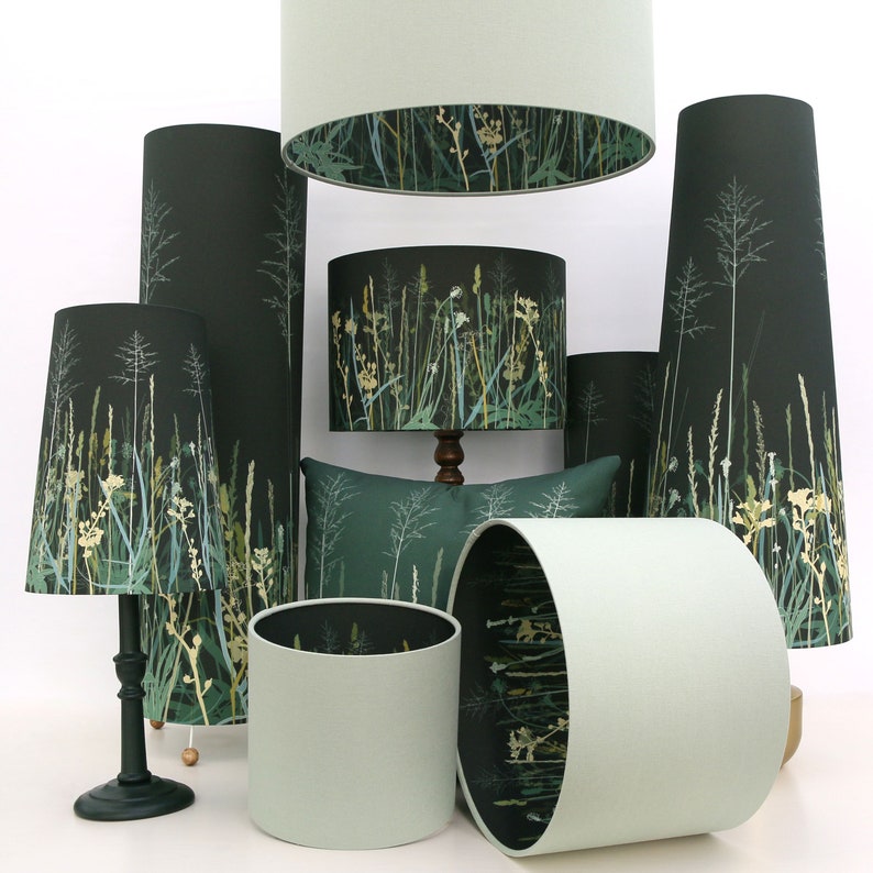 K&ouml;nnte beinhalten: Eine Sammlung von Lampenschirmen mit einem gr&uuml;n-wei&szlig;en Blumenmuster. Die Lampenschirme sind aus Stoff und haben verschiedene Formen und Gr&ouml;&szlig;en.
