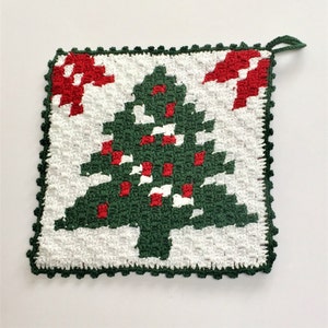 May include: A green crocheted Christmas tree pot holder with red and white accents. The pot holder has a crocheted border.