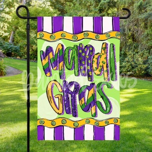 May include: A green, purple, and yellow garden flag with the text "Mardi Gras" in a whimsical font. The flag has a striped border and is displayed on a black metal flagpole.