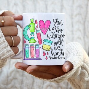 May include: White ceramic mug with a pink heart, a microscope, test tubes, and the text "She works willingly with her hands Proverbs 31:13"