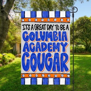 May include: A blue and orange garden flag with white stripes. It says "It's a great day to be a Columbia Academy Cougar".
