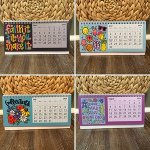 May include: A set of four 2024 desk calendars with spiral binding. Each calendar features a different design and month: May with the text "faith it til you make it", June with summer graphics, July with "God Bless the USA", and August with "You will never regret being kind".