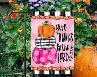 May include: A pink and black striped garden flag with a stack of pumpkins and the text "give THANKS to the LORD PSALM 136:1".