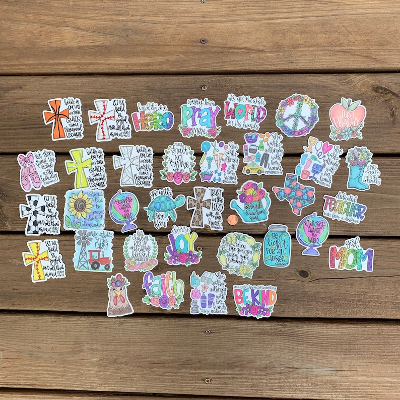 May include: A collection of colorful stickers with various designs and phrases. The stickers feature religious themes, inspirational quotes, and cute illustrations. Some of the phrases include "Let the beauty of what you love be what you do", "Trust in the Lord with all your heart", "Be Kind", and "Girl Mom".