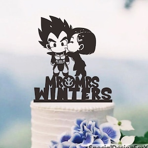 May include: Black and white silhouette cake topper featuring a cartoon couple kissing. The couple is dressed in anime-inspired clothing. The text "Mr & Mrs Winters" is below the couple.