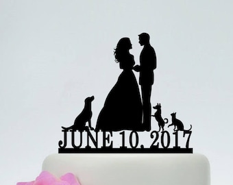 May include: Black silhouette cake topper of a bride and groom with three dogs. The topper says "JUNE 10. 2017" on the bottom.